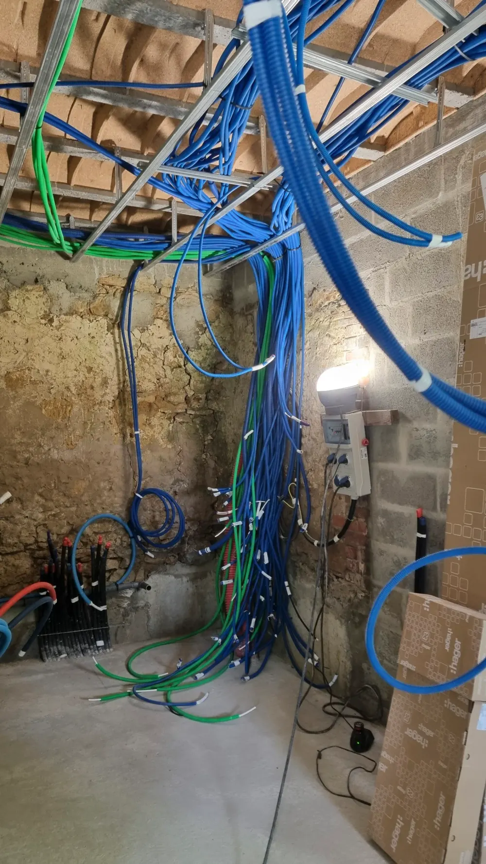 Passage de gaines électriques dans les murs et le plafond sur un chantier CM’Elec