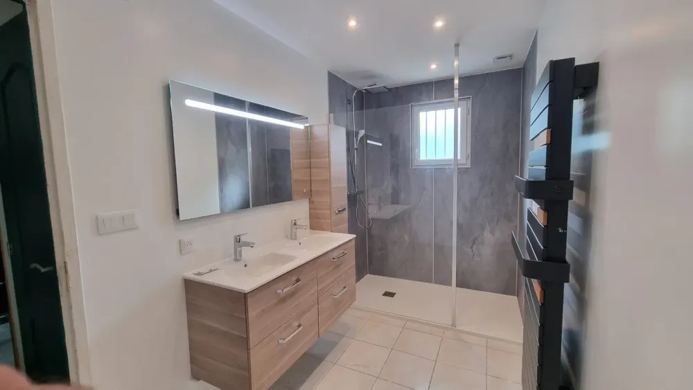 Salle de bains avec douche, double vasque, miroir éclairé et sèche-serviettes, réalisation CM’Elec